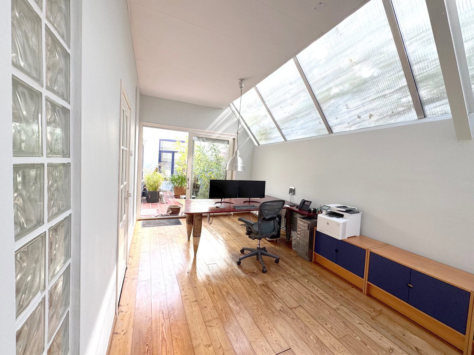 Interior view of a modern office space at Sloterweg 1257, Amsterdam, featuring a sloped glass ceilin.