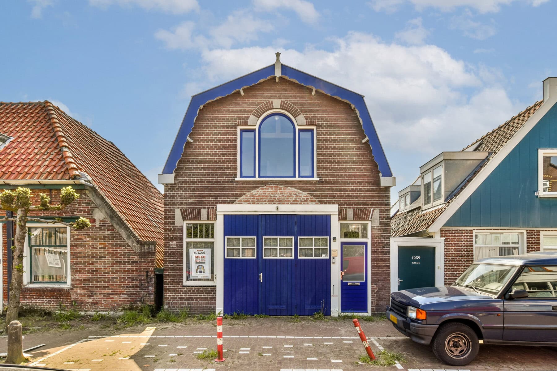 Historic brick house with blue accents in Amsterdam.