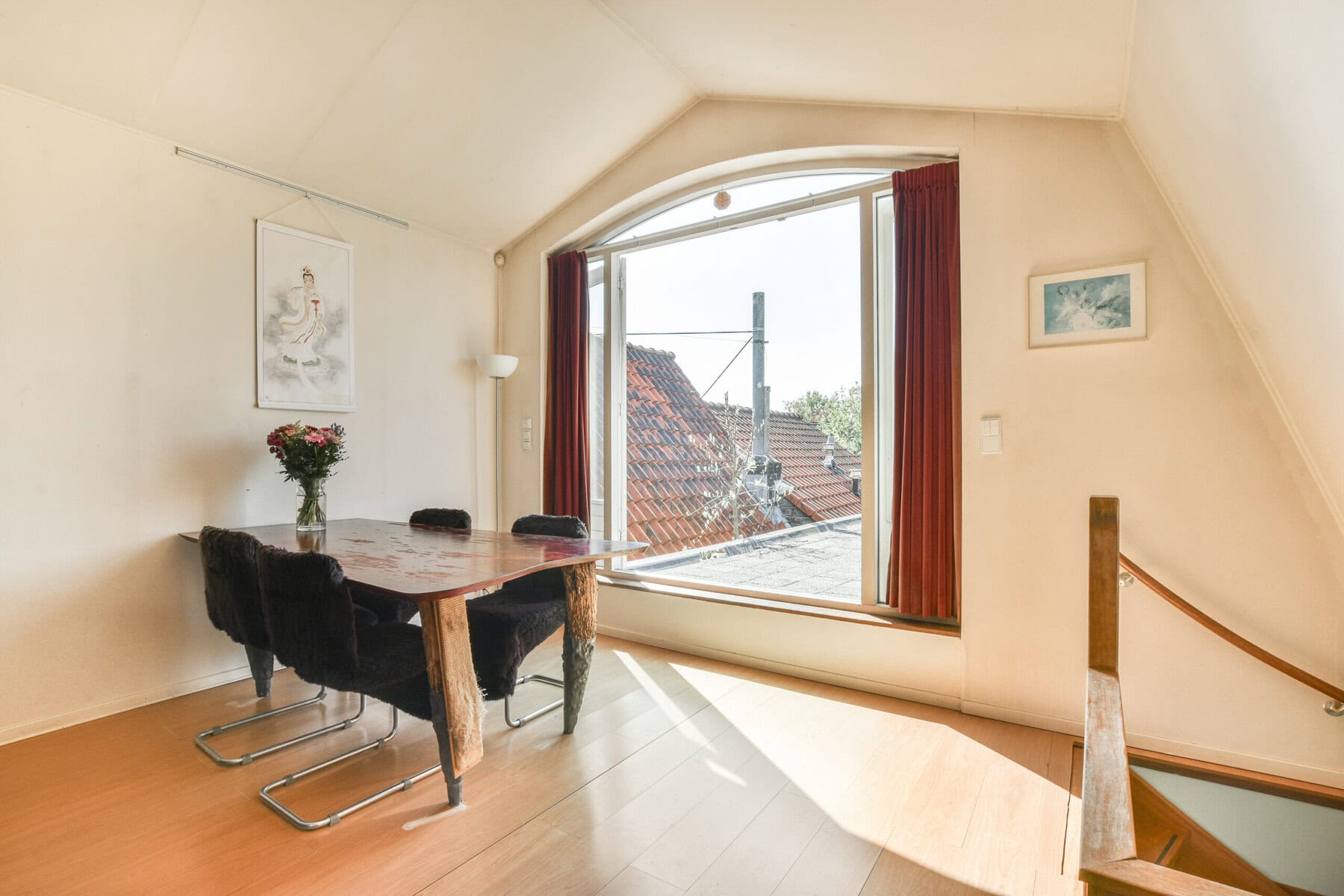 Bright room with large window overlooking rooftops in Amsterdam.